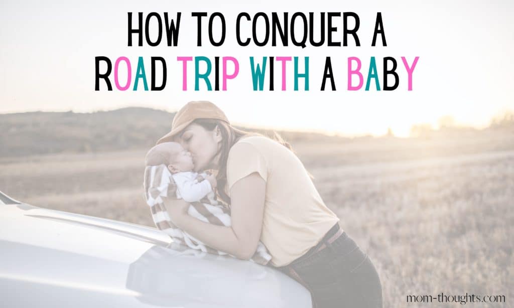 This is an image of a mother holding her baby on the hood of a car giving him a kiss on the cheek. There is text that says How To Conquer A Road Trip With A Baby. The image is on a post that outlines tips for going on a long road trip with a baby.