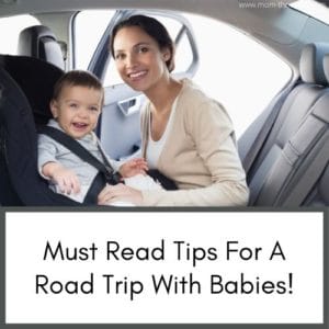 This image is of a baby in a car seat with the mom while on a road trip with baby. Both smiling at the camera.